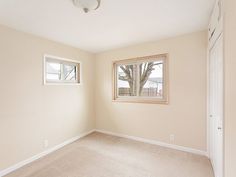 an empty room with two windows and no one in the house or someone is there