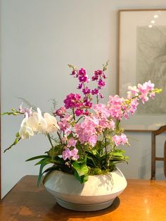 pink and white flowers in a vase on a table