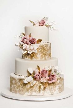 a three tiered wedding cake with pink and white flowers