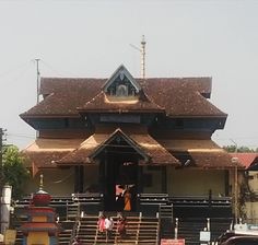 a large building with a clock on the top of it's roof next to parked cars