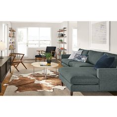 a living room filled with furniture and a cow hide rug on top of a hard wood floor