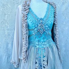 a mannequin wearing a blue dress with lace and beads on it's shoulders