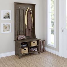 an entryway with a coat rack and baskets on the floor, next to a white door