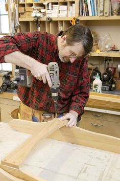 a man sanding wood with a drill