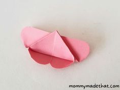 an origami heart shaped object on a white surface