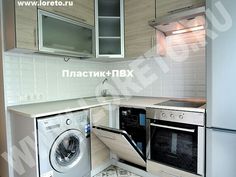 a kitchen with a washing machine in the middle of it and cupboards on both sides