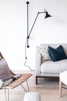 a living room with a couch, chair and floor lamp