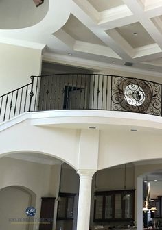 a clock mounted to the side of a wall in a living room next to a staircase