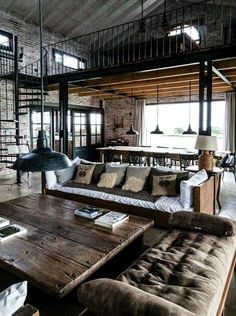 a living room filled with furniture and a spiral staircase leading up to the second floor