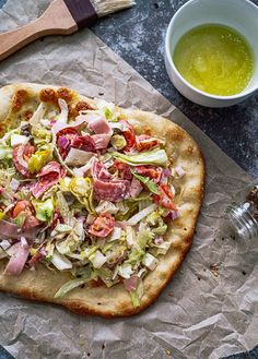 a pizza sitting on top of a piece of paper next to a cup of green tea