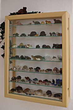 a wall mounted glass case filled with lots of different types of figurines