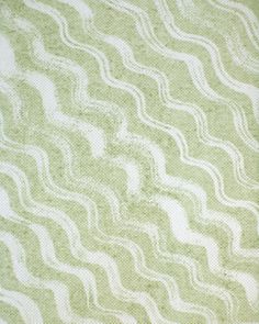 a green and white blanket with wavy lines on it