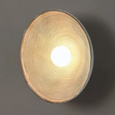 a light that is on the ceiling in front of a gray wall and grey floor