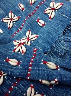 the fabric has been stitched together with white beads and red threads on it