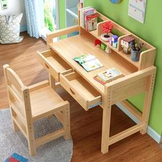 a child's wooden table and chair set in a playroom with green walls