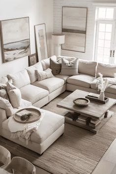 a living room filled with white furniture and lots of pillows on top of the couch