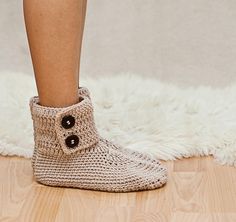 a close up of a person's legs wearing crocheted slippers with buttons