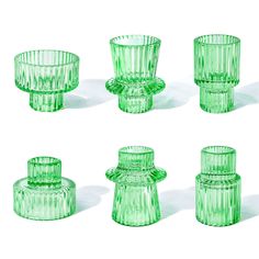 four green glass vases sitting next to each other