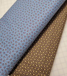 three different types of ties laid out on top of each other, one blue and the other brown