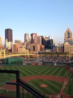 a baseball field with the city in the background