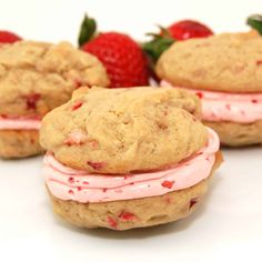 three strawberry shortcakes with frosting and strawberries on the side, sitting next to each other