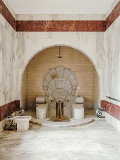 an old fireplace in a room with marble walls and flooring that has red and white stripes on it