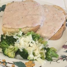 a plate topped with meat and vegetables covered in gravy on top of it