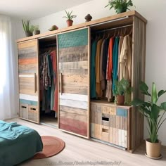 an open closet with clothes hanging on the doors and plants in potted planters