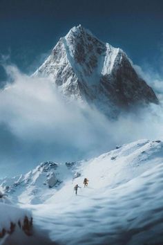 two skiers are skiing down a snowy mountain slope in front of a large snow - capped mountain