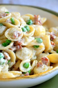 a bowl filled with pasta and peas on top of a table