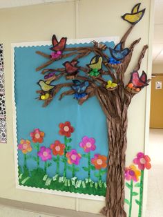 a bulletin board with flowers and butterflies on it in a classroom hallway or playroom