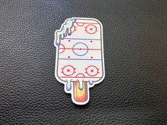 an ice cream sticker is shown on a black leather surface, with the goalie's line drawn across it