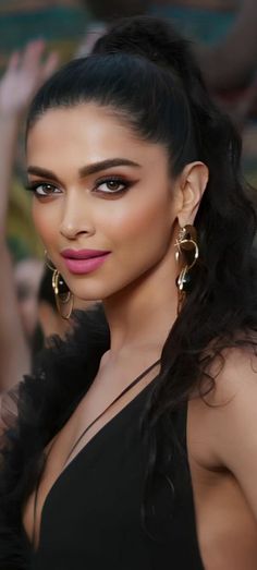 a woman in a black dress posing for the camera with her hand on her hip