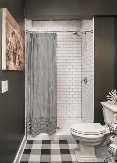 a bathroom with black and white checkered flooring, shower curtain, and toilet