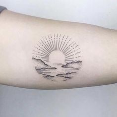 a person with a tattoo on their arm that has clouds and sun in the sky