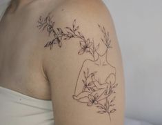 a woman's shoulder tattoo with flowers on it