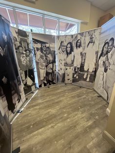 a group of people standing next to each other in front of a wall with pictures on it