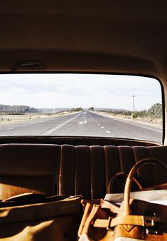 the back seat of a car looking out at an empty highway