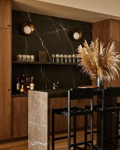 a modern kitchen with marble counter tops and bar stools next to the dining room table