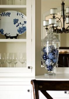 a china cabinet with blue and white dishes in the glass vases on top of it