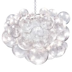 a chandelier hanging from a chain on a white wall with lots of glass balls