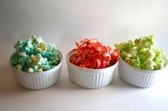 three white bowls filled with different colored popcorn