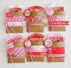 many different types of greeting cards are arranged on a wall with ribbons, tags and paper