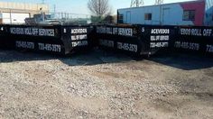 several black dump trucks are parked in the dirt