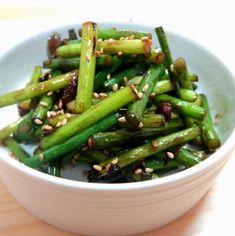 a white bowl filled with asparagus and sesame seeds