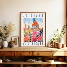 a poster is hanging on the wall above a table with potted plants and other items