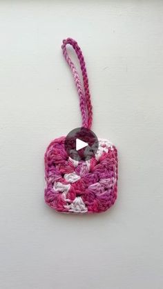 a pink and white crocheted ornament hanging from a hook on a wall