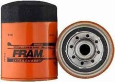 an orange and black oil filter next to a metal can with the word fram on it