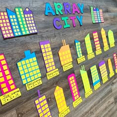 an array of city buildings on a wooden wall with colorful magnets attached to it