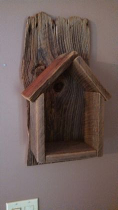 a wooden birdhouse mounted to the side of a wall